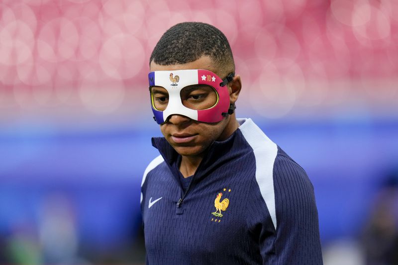 France's Kylian Mbappe wears a face mask as he runs during a training session in Leipzig, Germany, Thursday, June 20, 2024. France will play against Netherland during their Group D soccer match at the Euro 2024 soccer tournament on June 21. (AP Photo/Hassan Ammar)