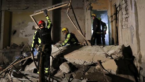 Emergency services workers move rubble after a Russian strike on a residential building in Kharkiv, Ukraine early Sunday Sept. 22, 2024. (Kharkiv Regional Military Administration via AP)