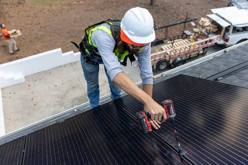 Joe McClain, an installer for Creative Solar USA, installs solar panels on a home in Ball Ground, Georgia on December 17, 2021. Solar advocates want the Public Service Commission to expand a popular residential and commercial solar program that filled up last year.