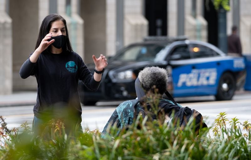 200923-Atlanta-Donia Hanaei, a harm reduction specialist with the Atlanta/Fulton Pre-Arrest Diversion Initiative (PAD), talks with a person at Woodruff Park in downtown Atlanta on Wednesday, September 23, 2020. PAD helps divert people who face an immediate arrest to social services that can address the persons needs and keep them out of the legal system. Ben Gray for the Atlanta Journal-Constitution