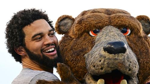 Chicago Bears quarterback Caleb Williams gets a hug from the mascot during warmups before an NFL exhibition Hall of Fame football game against the Houston Texans, Thursday, Aug. 1, 2024, in Canton, Ohio. (AP Photo/David Dermer)