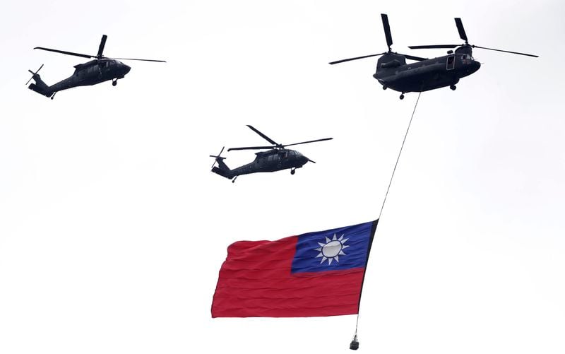 FILE - Helicopters fly over with Taiwan national flag during an inauguration celebration of Taiwan's President Lai Ching-te in Taipei, Taiwan, on May 20, 2024. China's military held exercises surrounding Taiwan on Thursday, May 23, 2024, in what it called punishment for separatist forces seeking independence on the self-governed island where a new president took office this week. (AP Photo/Chiang Ying-ying, File)