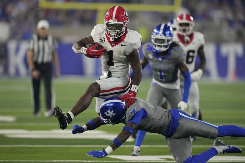 Georgia running back Trevor Etienne (1) leaps over Kentucky defensive back Kristian Story (4) during the second half of an NCAA college football game, Saturday, Sept. 14, 2024, in Lexington, Ky. (AP Photo/Darron Cummings)