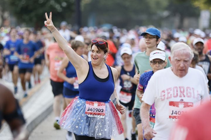 Runners show enthusiam at the start of the 55th running of the Atlanta Journal-Constitution Peachtree Road Race in Atlanta on Thursday, July 4, 2024.   (Miguel Martinez / AJC)