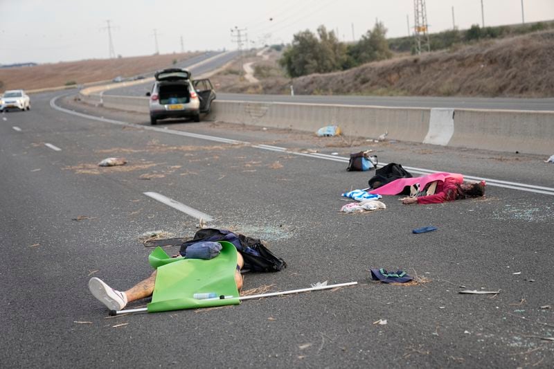 Israelis killed by Hamas militants lie on the road near Sderot, Israel, on Oct. 7, 2023. (AP Photo/Ohad Zwigenberg)