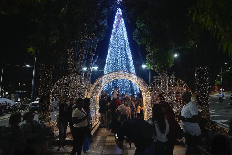 People take photos in front of Christmas decorations in Caracas, Venezuela, Tuesday, October. 1, 2024. (AP Photo/Ariana Cubillos)