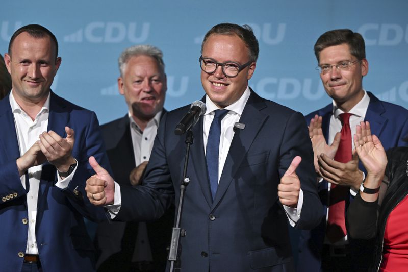 Mario Voigt, center, speaks after the first exit polls for the state elections in Thuringia and Saxony are released, in Erfurt, Germany, Sunday, Sept. 1, 2024. (Martin Schutt/dpa via AP)