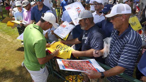 Rory McIlroy signs autographs for fans behind the ninth green during the practice rounds for the Tour Championship at East Lake Golf Club, on Wednesday, Aug. 28, 2024, in Atlanta. Wednesday was the first day the public was allowed on the course. (Jason Getz / AJC)
