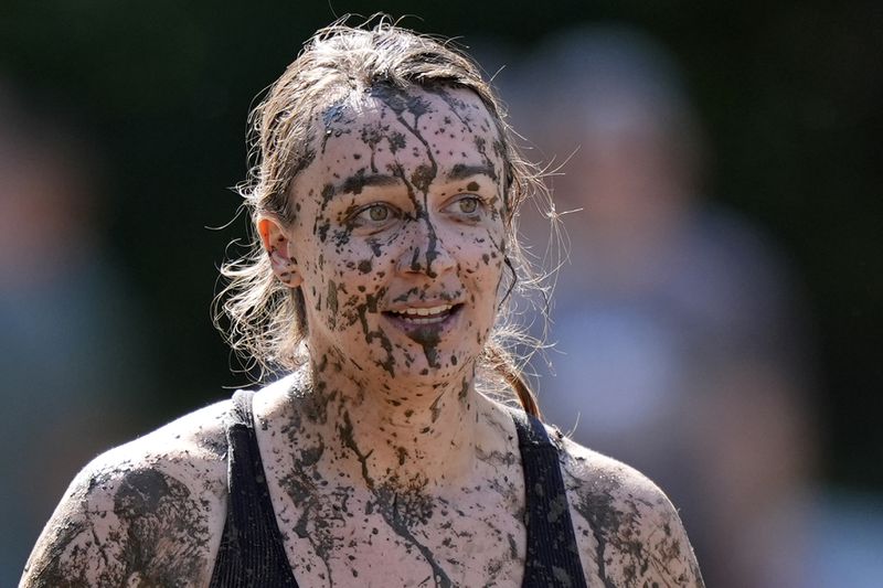 Amanda Lackey, of Bow, N.H., is splattered with mud as she walks back to the huddle during a women's football game at the Mud Bowl in North Conway, N.H., Saturday, Sept. 7, 3024. (AP Photo/Robert F. Bukaty)