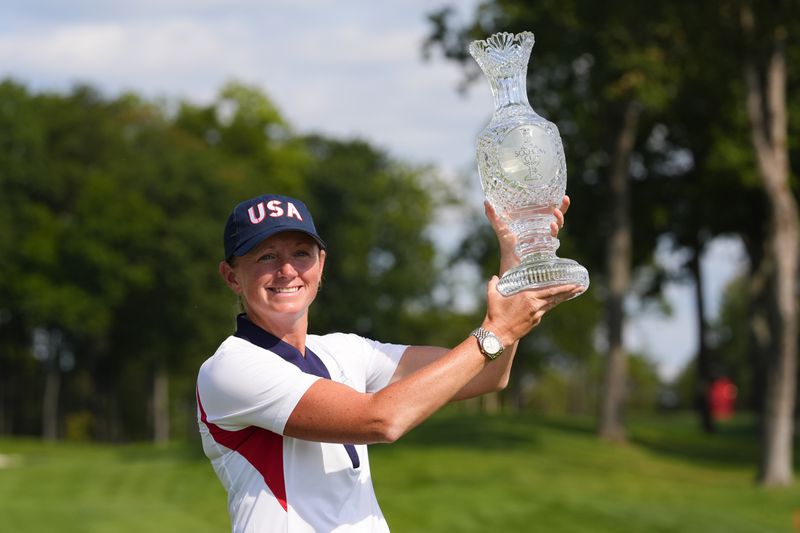 United States Captain Stacy Lewis lifts the winner's trophy after her team won the Solheim Cup golf tournament against Europe at the Robert Trent Jones Golf Club, Sunday, Sept. 15, 2024, in Gainesville, Va. (AP Photo/Matt York)