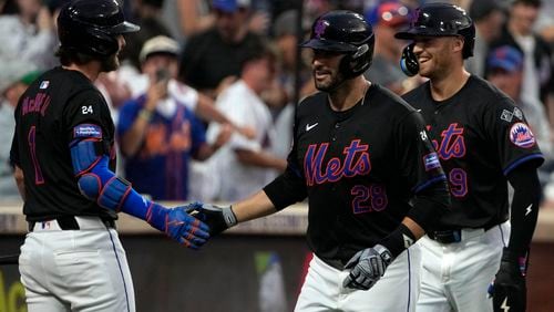 New York Mets' Jeff McNeil, left, J.D. Martinez, center, and Brandon Nimmo, right, celebrate after Martinez hit a grand slam also leading to Nimmo, Francisco Lindor and Tyrone Taylor to score during the third inning of a baseball game against the Atlanta Braves, Friday, July 26, 2024, in New York. (AP Photo/Pamela Smith)