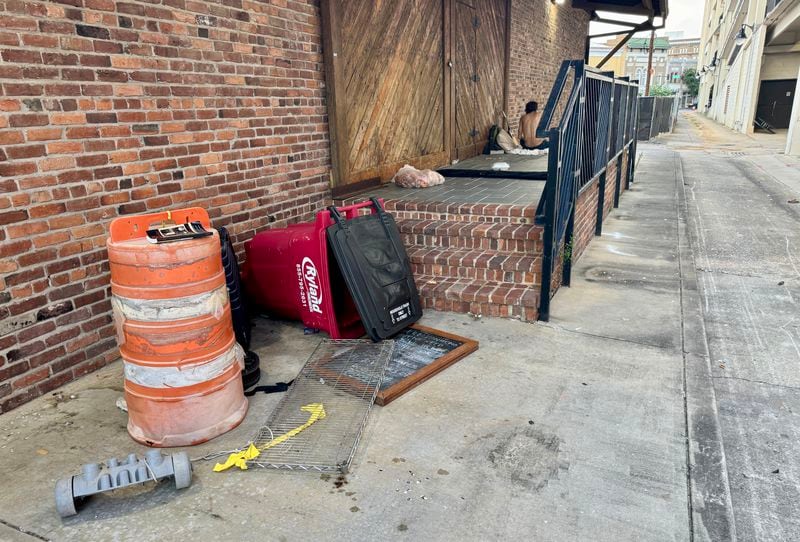 Some of Macon's homeless people still sleep near the location where Albert Kenneth Knight Jr., 59, was beaten to death in late May. This photograph taken in early August shows the porch-like location, at the top of the steps just above the red trash bin, where Knight lay resting when he was attacked in the predawn hours of May 24. (Joe Kovac Jr. / AJC)