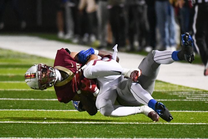Trajen Greco, quarterback for Mill Creek, is tackled by Westlake in a high school state playoffs quarterfinal on  Friday, Nov. 25, 2022 in Hoschton, Georgia. (Jamie Spaar for the Atlanta Journal Constitution)