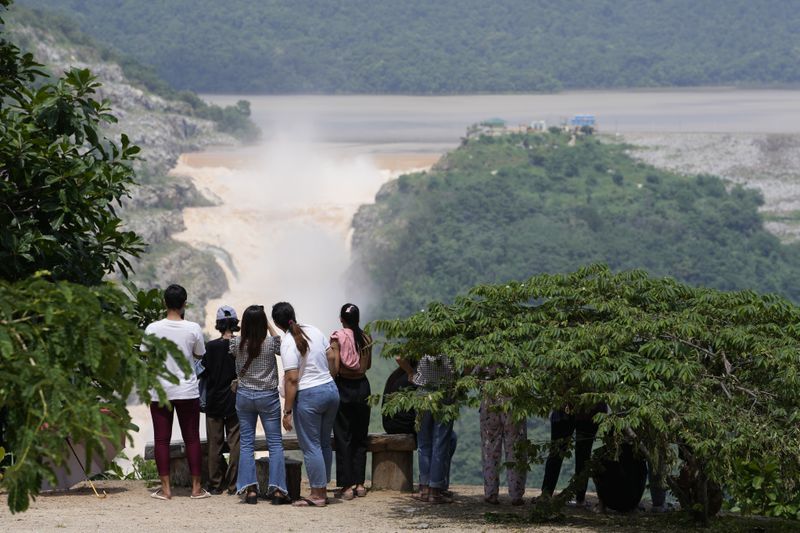 People watch as water is released from Paung-Laung dam in Naypyitaw, Myanmar, Sunday, Sept. 15, 2024. (AP Photo/Aung Shine Oo)