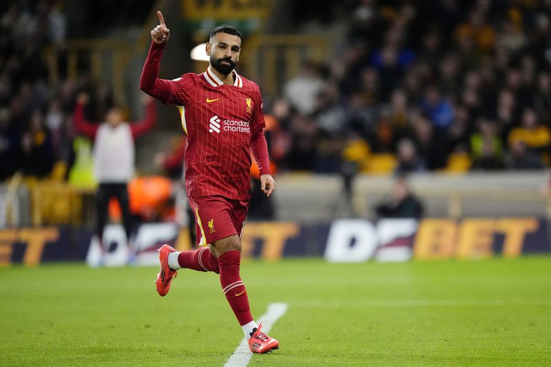 Liverpool's Mohamed Salah celebrates scoring his side's second goal of the game during the English Premier League soccer match between Wolverhampton Wanderers and Liverpool at the Molineux Stadium in Wolverhampton, England, Saturday, Sept. 28, 2024. (Nick Potts/PA via AP)