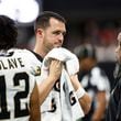 New Orleans Saints quarterback Derek Carr, center, speaks on the sidelines during the second half of an NFL football game against the Atlanta Falcons, Sunday, Sept. 29, 2024, in Atlanta. (AP Photo/Butch Dill)