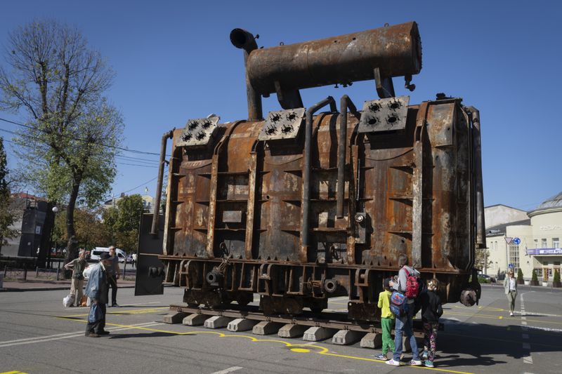 People look at a burnt transformer from one of power plants badly damaged in one of Russia's recent missile attacks on energy system in Kyiv, Ukraine, Thursday, Sept. 19, 2024. (AP Photo/Efrem Lukatsky)