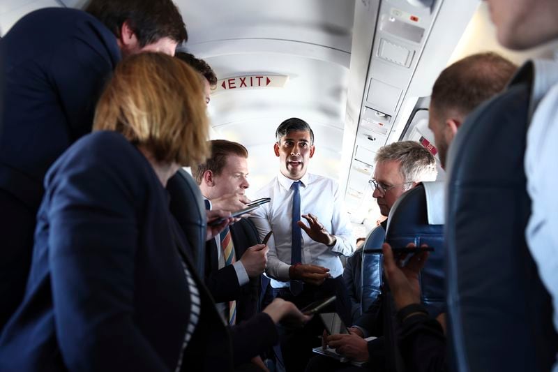 British Prime Minister Rishi Sunak talks to journalists on his plane as he travels from Northern Ireland to Birmingham during a day of campaigning for this year's General Election due to be held on July 4, on Friday May 24, 2024. (HENRY NICHOLLS/Pool photo via AP)