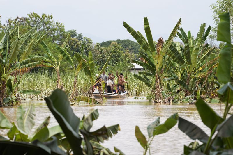 Local residents travel by boat on a flooded road in Naypyitaw, Myanmar, Saturday, Sept. 14, 2024. (AP Photo/Aung Shine Oo)