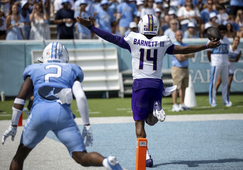 James Madison quarterback Alonza Barnett III (14) celebrates after running in a touchdown during the first half of an NCAA college football game against North Carolina in Chapel Hill, N.C., Saturday, Sept. 21, 2024. (Daniel Lin/Daily News-Record via AP)