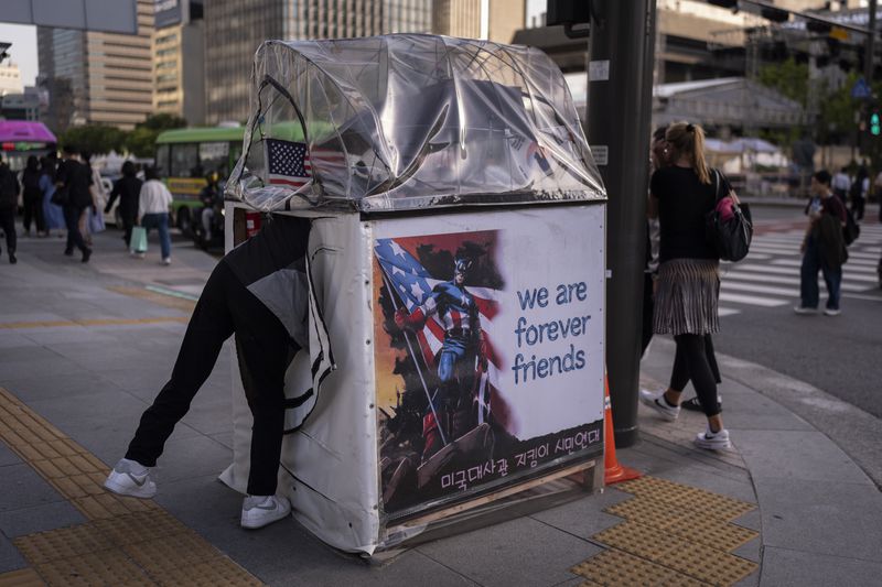 Jung Dong-won, a group member organized to show support for and protect the U.S. embassy, enters a small booth adorned with a Captain America image across the street from the embassy in Seoul on Thursday, May 23, 2024. (AP Photo/Jae C. Hong)