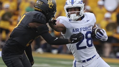 Air Force running back Aiden Calvert stiff-arms Baylor linebacker Keaton Thomas while running toward the sidelines during the first half of an NCAA college football game, Saturday, Sept. 14, 2024, in Waco, Texas. (Rod Aydelotte/Waco Tribune-Herald via AP)