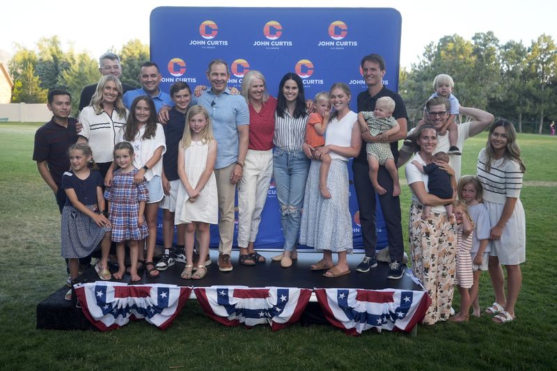 U.S. Rep. John Curtis poses with his family following his win during an election night party, Tuesday, June 25, 2024, in Provo, Utah. Curtis has won the Utah GOP primary for Mitt Romney's open U.S. Senate seat, defeating one opponent who was endorsed by former President Donald Trump and others who said they supported Trump's agenda. (AP Photo/Rick Bowmer)