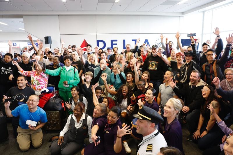 Travelers and Delta Airlines employees take photos Monday, April 8, 2024, at the gate of Dallas Fort Worth International Airport before the eclipse flight to Detroit. (Natrice Miller/AJC)