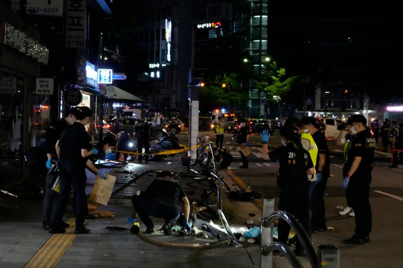 Police officers investigate a car accident scene near Seoul City Hall in downtown Seoul, South Korea, early Tuesday, July 2, 2024. A car hit pedestrians waiting at a traffic light in central Seoul on Monday evening, killing nine people and injuring four, South Korea's emergency officials said. (AP Photo/Ahn Young-joon)