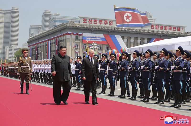 In this photo provided Thursday, June 20, 2024, by the North Korean government, Russian President Vladimir Putin, center, and North Korea's leader Kim Jong Un, center left, review an honor guard during the official welcome ceremony in the Kim Il Sung Square in Pyongyang, North Korea, Wednesday, June 19. The content of this image is as provided and cannot be independently verified. Korean language watermark on image as provided by source reads: "KCNA" which is the abbreviation for Korean Central News Agency.(Korean Central News Agency/Korea News Service via AP)