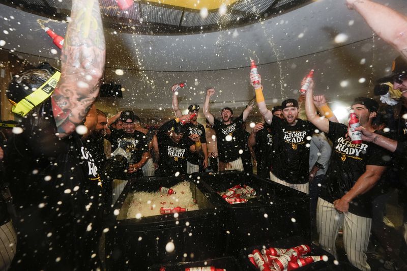 San Diego Padres players celebrate in the dugout after defeating the Atlanta Braves in Game 2 of an NL Wild Card Series baseball game Wednesday, Oct. 2, 2024, in San Diego. (AP Photo/Gregory Bull)