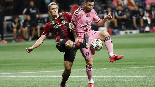 Atlanta United midfielder Bartosz Slisz (6) fights for the ball with Inter Miami forward Lionel Messi (10) during the second half of an MLS soccer match on Wednesday, Sept. 18, 2024, in Atlanta. (Miguel Martinez/Atlanta Journal-Constitution via AP)