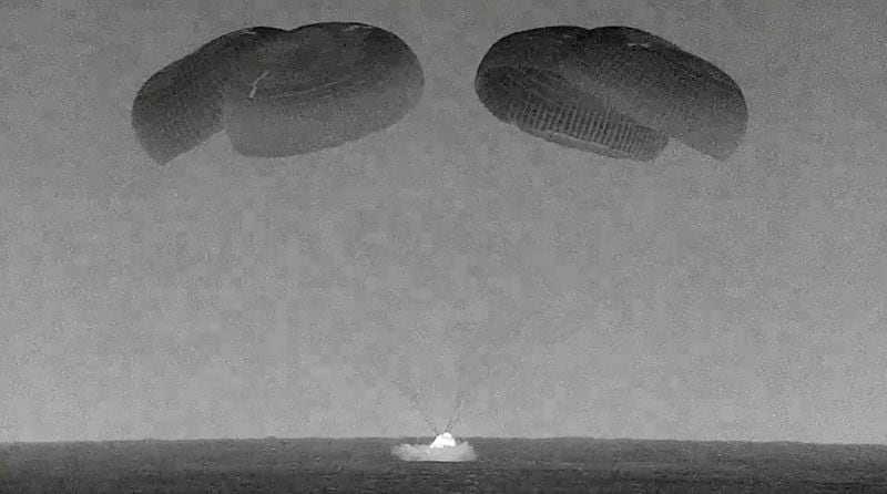 This black and white, thermal image made from SpaceX video shows its capsule, center, carrying tech entrepreneur Jared Isaacman with his crew as it splashes down in the Gulf of Mexico near Florida's Dry Tortugas early Sunday, Sept. 15, 2024. (SpaceX via AP)