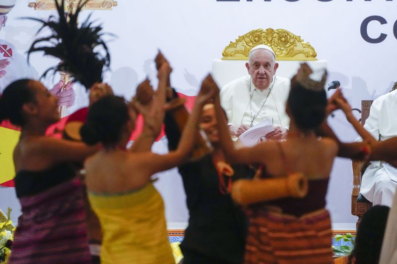 Pope Francis looks at traditional dancers as he arrives at the Centro de Convenções in Díli, East Timor, Wednesday, Sept. 11, 2024, for a meeting with young people. In East Timor Francis had to negotiate perhaps the most sensitive issue of his trip to Asia and Oceania clouding the visit: the case of Bishop Carlos Ximenes Belo, the revered national hero who won the Nobel Peace Prize for his nonviolent independence campaign. (AP Photo/Gregorio Borgia)