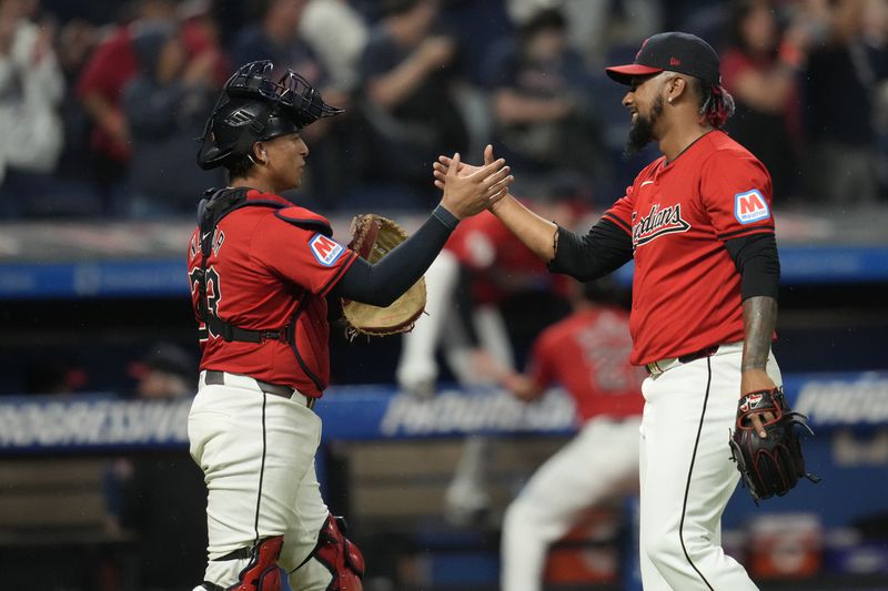 Cleveland Guardians catcher Bo Naylor, left, and relief pitcher Emmanuel Clase, right, shake hands after the Guardians defeated the Cincinnati Reds in a baseball game in Cleveland, Tuesday, Sept. 24, 2024. (AP Photo/Sue Ogrocki)