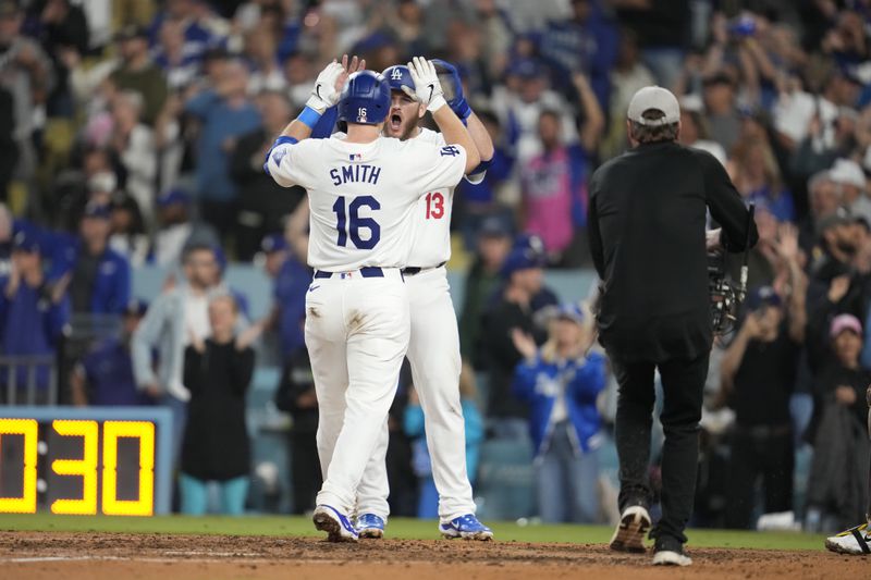 Los Angeles Dodgers' Will Smith (16) celebrates with teammate Max Muncy after hitting a two-run home run during the seventh inning of a baseball game against the San Diego Padres, Thursday, Sept. 26, 2024, in Los Angeles. (AP Photo/Ashley Landis)