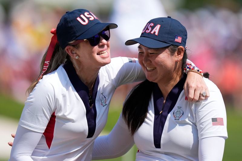 United States' Allisen Corpuz, right, gets a hug from Paula Creamer after Corpuz sinked a putt on the 14th green during a Solheim Cup golf tournament singles match at the Robert Trent Jones Golf Club, Sunday, Sept. 15, 2024, in Gainesville, Va. (AP Photo/Chris Szagola)