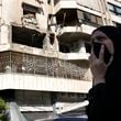 A woman reacts in front an apartment in a multistory building hit by Israeli airstrike, in central Beirut, Lebanon, Thursday, Oct. 3, 2024. (AP Photo/Hussein Malla)