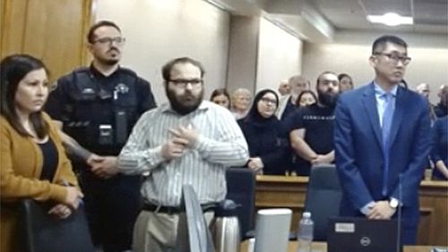 In this image taken from video provided by the Colorado Judicial Branch, Ahmad Alissa, third from left, stands for the verdict in his trial for the 2021 Colorado supermarket shootings, Monday, Sept 23, 2024, in Boulder, Colo. (Colorado Judicial Branch via AP)