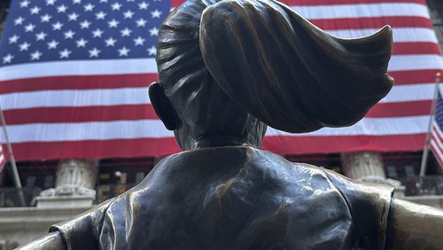 FILE - The Fearless Girl statues faces the New York Stock Exchange on July 2, 2024, in New York. Global stocks are mixed on Friday, July 12, 2024, with the Japanese yen losing some of its gains after the latest U.S. update on inflation bolstered Wall Street's belief that relief on interest rates may come as soon as September. (AP Photo/Peter Morgan, File)