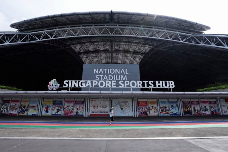 A woman jogs along the promenade of the National Stadium in Singapore, Sunday, Sept. 8, 2024. (AP Photo/Suhaimi Abdullah)