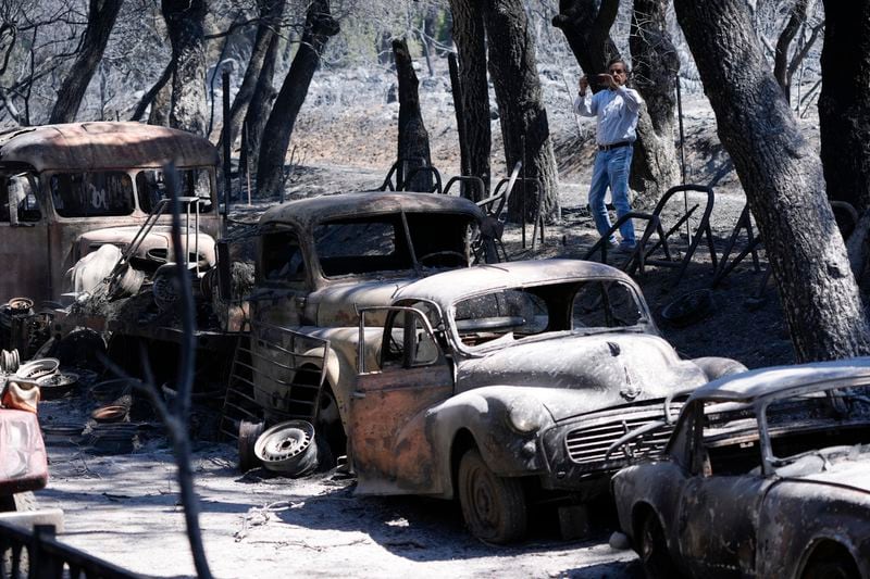 A reporter takes cell phone images of the devastation left behind by the Airport Fire Wednesday, Sept. 11, 2024, in El Cariso Village, in unincorporated Riverside, County, Calif. (AP Photo/Gregory Bull)