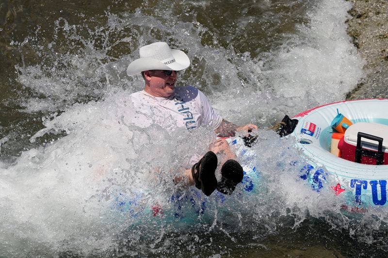 A tuber floats the cool Comal River as temperatures in South Texas hit triple-digit numbers, Wednesday, Aug. 21, 2024, in New Braunfels, Texas. (AP Photo/Eric Gay)