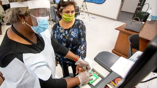 Usha Malhotia (R) gets her fingerprints taken during orientation for substitute teachers at the J. Alvin Wilbanks Instructional Support Center in Suwanee on July 2. Gwinnett County schools have pushed to have all teacher vacancies filled by July 20. STEVE SCHAEFER FOR THE ATLANTA JOURNAL-CONSTITUTION