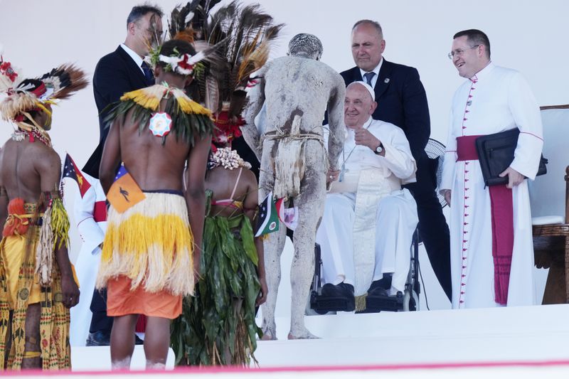 Pope Francis, third right, meets with people in traditional dress after giving an address during meeting with young people in the Sir John Guise Stadium in Port Moresby, Papua New Guinea, Monday, Sept. 9, 2024. (AP Photo/Mark Baker)