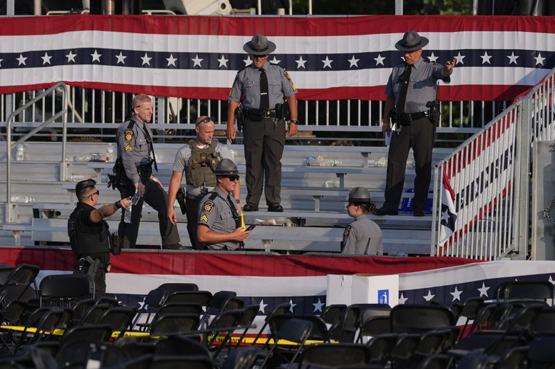 Law enforcement officers gather at campaign rally site for Republican presidential candidate former President Donald Trump is empty Saturday, July 13, 2024, in Butler, Pa. Trump's campaign said in a statement that the former president was "fine" after a shooting at his rally in Butler (AP Photo/Evan Vucci)