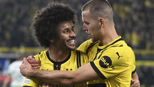 Dortmund's Karim Adeyemi, left, celebrates with Waldemar Anton, after scoring his side's third goal during the Champions League opening phase soccer match between Borussia Dortmund and Celtic FC in Dortmund, Germany, Tuesday, Oct. 1, 2024. (Bernd Thissen/dpa via AP)