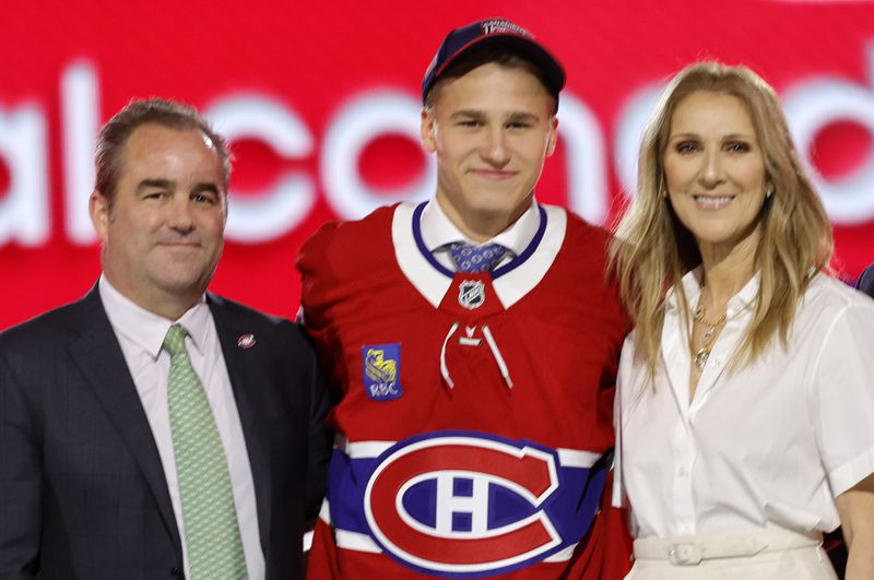 Ivan Demidov, center, poses, after being selected by the Montreal Canadiens during the first round of the NHL hockey draft Friday, June 28, 2024, in Las Vegas. The announcement was made by singer Celine Dion, right. (AP Photo/Steve Marcus)