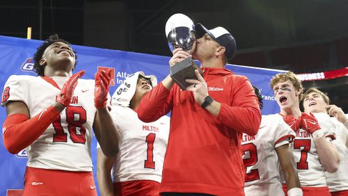 Milton head coach Ben Reaves kisses the trophy after their win against Walton in the Class 7A GHSA State Championship game at Mercedes-Benz Stadium, Wednesday, December. 13, 2023, in Atlanta. Milton won 31-21. (Jason Getz / Jason.Getz@ajc.com)