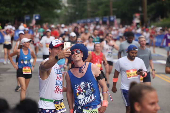 Runners pose for selfie at the finish of the 55th running of the Atlanta Journal-Constitution Peachtree Road Race in Atlanta on Thursday, July 4, 2024.   (Jason Getz / AJC)